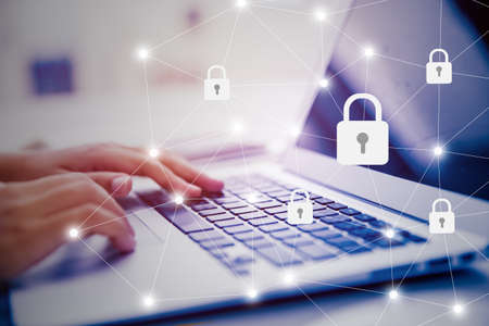Select the icon security on the virtual display. Side view of female hand typing keyboard. Business, technology, internet and networking concept.の写真素材