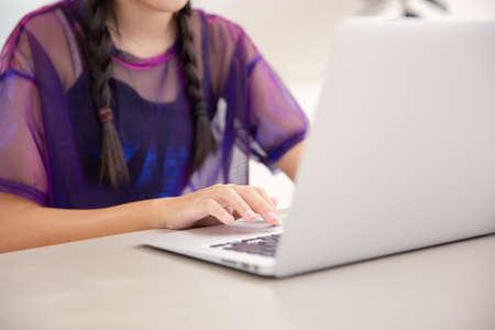 Beautiful young Asian girl working at a coffee shop with a laptop.female freelancer connecting to internet via computer. Casual Thinking Browsing Conceptの写真素材