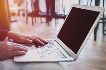 Young successful freelancer man work on his laptop while sitting at cafe, intelligent attractive man student using computer for browse Internet.の写真素材
