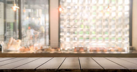 Blank top dark wooden bar counter with blur cafe background and night pub of restaurant, cafeteria...