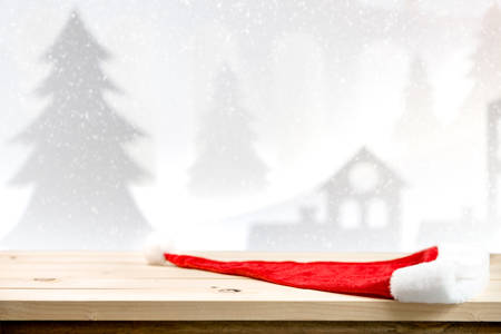 Christmas holiday background with empty wooden table top over christmas pine tree and house for montage product display.の写真素材
