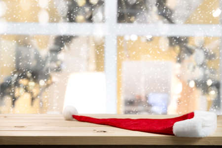 Christmas holiday background with empty wood table and christmas hat. In winter season.の写真素材