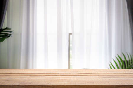 Blur background of white window glass with empty of wood table. Using for Mock up template for craft...
