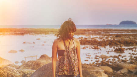 Young woman in casual style fashion Standing on the beach. Relaxing and enjoy holiday at tropical paradise beach. Girl in summer vacation. Summer vibes.の写真素材