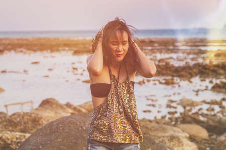 Young woman in casual style fashion Standing on the beach. Relaxing and enjoy holiday at tropical paradise beach. Girl in summer vacation. Summer vibes.の写真素材