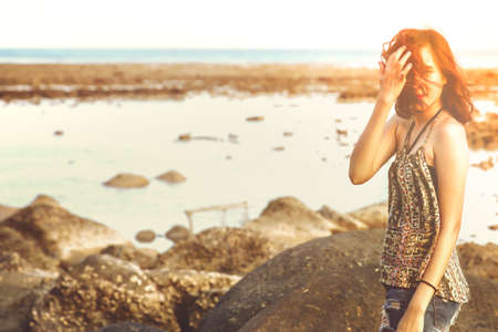 Young woman in casual style fashion lying on the beach. Relaxing and enjoy holiday at tropical paradise beach. Girl in summer vacation. Summer vibes.の写真素材