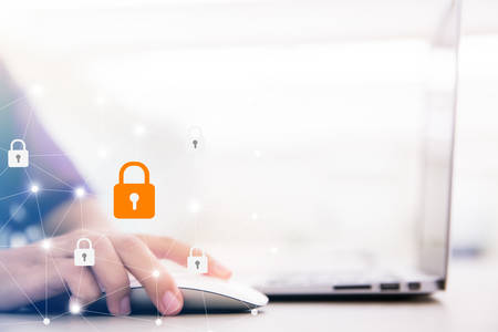 Young businesswoman working on his laptop in the office, select the icon security on the virtual display. Business, technology, internet and networking concept.の写真素材