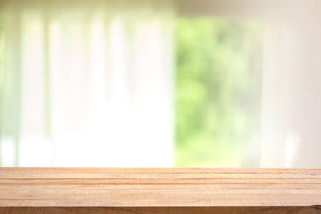 Empty wood table with blur curtain with window green garden from background. For montage product display.の写真素材