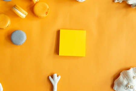 Top view of tasty orange yellow macarons and blank note. Concepts ideas background on yellow paper, flatlay and copy Space. Using for Mock up template for display of your design,Banner for advertise of product.の写真素材
