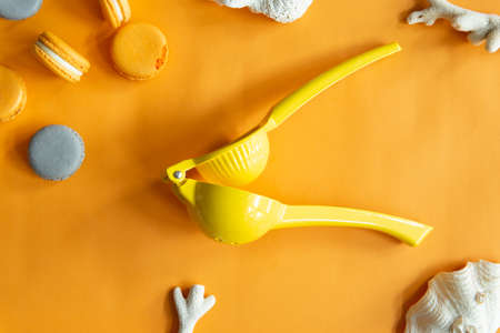 Top view of tasty  yellow macarons and orange squeez. Summer Concepts ideas background on yellow...