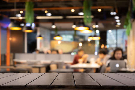 Empty wooden table in front of Blur background of coffee shop or restaurant interior abstract. Using for Mock up template for display of your design or montage  products.の写真素材