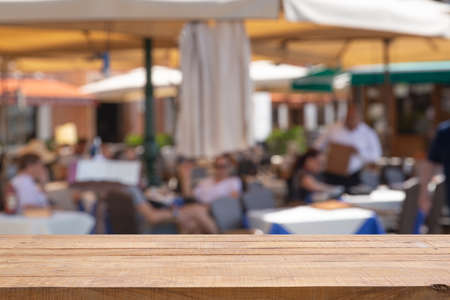 Empty table with Blurred abstract background of outdoor cafe in Milan, Italy. Outdoor cafe with tables, chairs at the old town.の写真素材