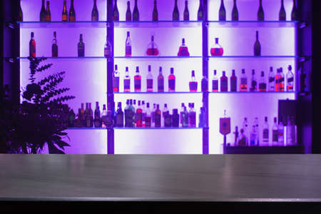 Empty black stone bar counter with defocused background and bottles of restaurant, bar or cafeteria background /for your product displayの写真素材