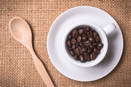 top view coffee cup fille dwith coffee beans on backgroundの写真素材