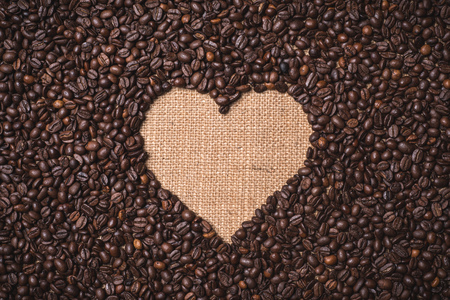 top view heart shape coffee beans on juta textileの写真素材