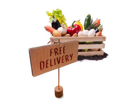 Organic vegetables in wooden rustic box and topsoil with cardboard square tag. Price tag, gift tag, sale tag,  label isolated on white backgroundの写真素材