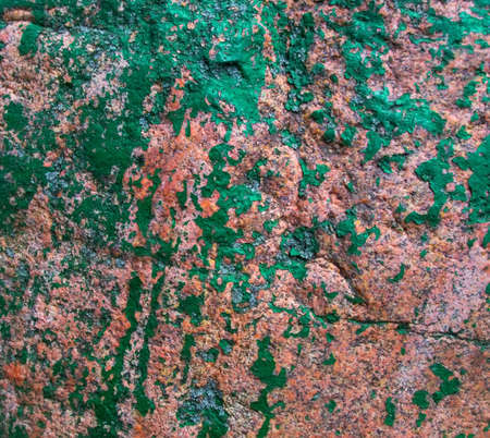 Old painted granite stone rock background. In brown, green, pink and red colors
