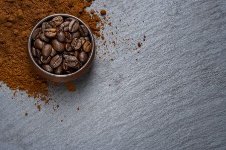 roasted coffee beans in a cup on a stone stand. Loose ground coffee. Dark background.の写真素材