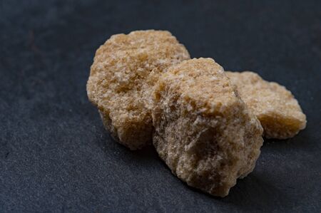 Cane brown sugar on a dark stone backgroundの写真素材
