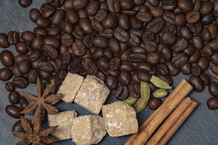 Composition of coffee and cane sugar on a stone background with the addition of anise, cinnamon and...
