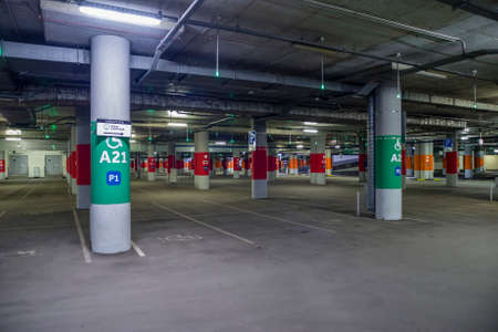 Moscow, Russia - April 22, 2020: Asphalt, dimly lit empty mall garage with ceiling lights.のeditorial素材