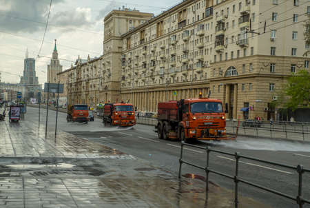 Russia, Moscow - May 7, 2020: water trucks water the highway. Housing and utilities use water to clean expensive dustのeditorial素材