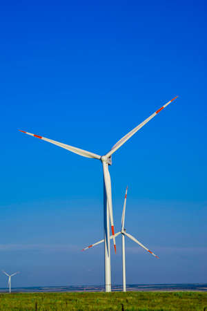 green field with wind turbines generating electricity. Environmentally friendly electricityの写真素材
