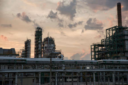 Refinery tower at a petrochemical plant with cloudy sky. After sunset.