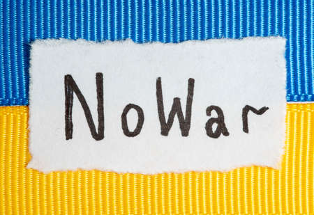 Handwritten inscription No War in black on paper against the background of the Ukrainian flagの写真素材