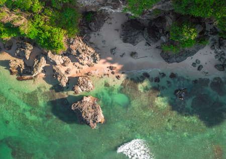 Stunning drone view of Balis tranquil coastline with crystal clear waters and lush greeneryの写真素材