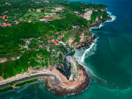 Breathtaking drone view of Pura Luhur Uluwatu Temple and the emerald coastline in the summer sunの写真素材