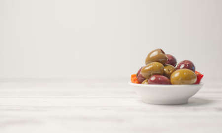 Olives in a bowl with white backgroundの写真素材