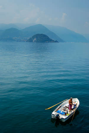 fishing on Lake Como,Bellagio in the distanceのeditorial素材