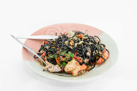 Black spaghetti with seafood on white backgroundの写真素材