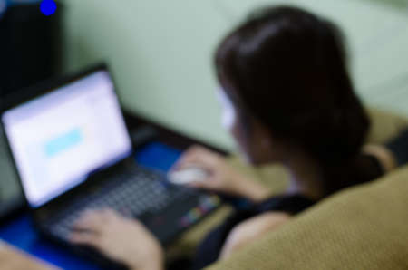 Working woman with computer, image blur backgroundの写真素材