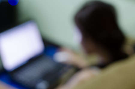 Working woman with computer, image blur backgroundの写真素材