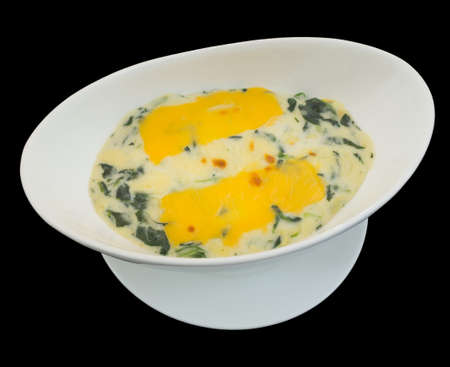 Baked spinach with cheese isolated on the black backgroundの写真素材