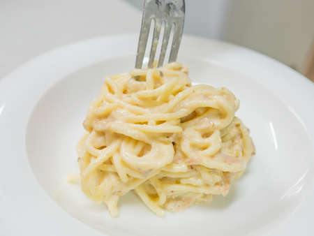 Pasta Carbonara with tuna on a white plateの写真素材