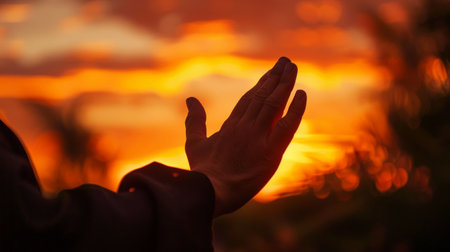 Close-up of tai chi hands silhouetted against a fiery sunset, conveying a sense of power and tranquilityの素材