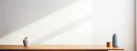 A vase filled with white flowers on a wooden table in front of a white wall.の素材