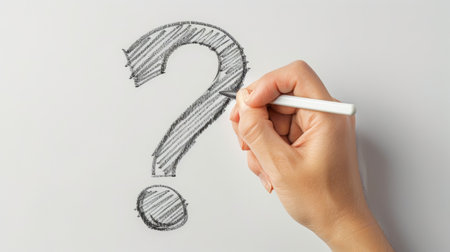 A single hand drawing a question mark on a whiteboard, prompting inquiry and problem-solving discussions.の素材