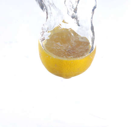Half a lemon splashing in some waterの写真素材
