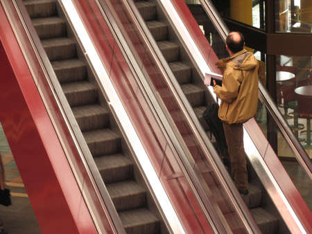 Man going up with the escalator in a cultural center.