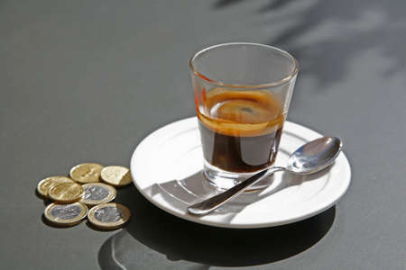 Glass of espresso and Euro coins.の写真素材