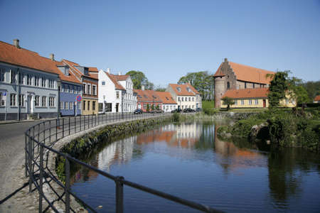 Beautiful old houses along the moat. The more than 800 years old Nyborg Castle in the backgroundの写真素材