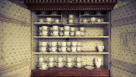 Beautiful antique Swedish cupboard from 1732 filled with cups. Cross processed to underline the mood.の写真素材