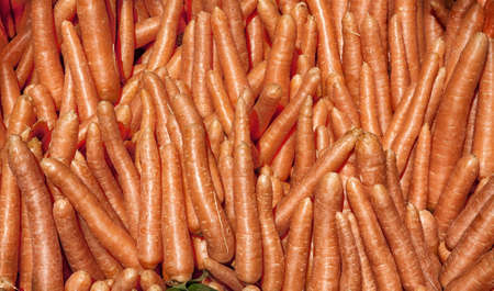 Heap of carrots for sale in a market place の写真素材