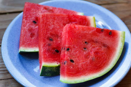 Juicy big red watermelon lying on a woodenの写真素材