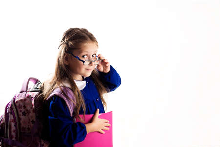 Caucasian elementary age schoolgirl with glasses posing in unifo