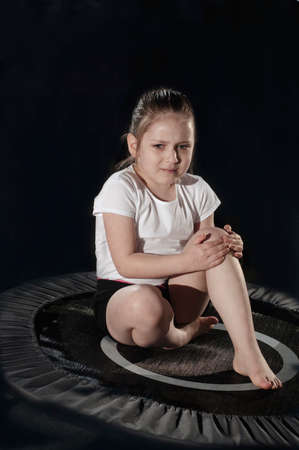 Little caucasian female gymnast crying for a trauma of kneel.の写真素材